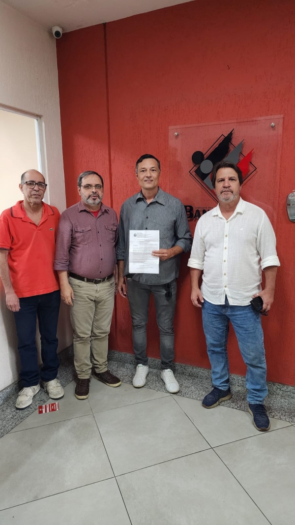 : Francisco Rodrigues (ao centro), bancário do Santander, com o documento de reintegração em mãos, ao lado de Wanderlei Souza (esq.), do presidente do Sindicato, José Ferreira, e de Marcos Vicente, representante da COE