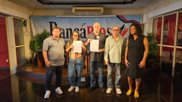 Viviane Medeiros, do Itaú, e Luis Henrique Carvalho,  do Bradesco, mostrando os documentos de suas  reintegrações, ao lado de dirigentes do Sindicato