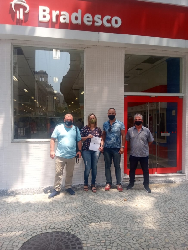 FELIZ COM A VITÓRIA - A bancária Erika Nascimento de posse de seu documento de reintegração, ao lado dos dirigentes sindicais Sérgio Menezes (E), Gilberto Leal e Geraldo Ferraz